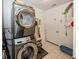 Convenient laundry room with a stacked washer and dryer and white tile floors at 5982 Blue Heron Way, Plainfield, IN 46168
