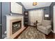 This living room boasts a fireplace, hardwood floors, and a comfortable armchair at 5982 Blue Heron Way, Plainfield, IN 46168