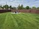 Well-manicured backyard features a fire pit with Adirondack chairs, surrounded by a wood fence at 628 Williams Ct, Greenwood, IN 46142