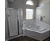 Bathroom with a large soaking tub, a separate glass-enclosed shower and a window for natural light at 6431 Furnas Rd, Indianapolis, IN 46221