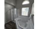 Bright bathroom with a soaking tub and a separate shower with glass doors and updated fixtures at 6431 Furnas Rd, Indianapolis, IN 46221