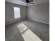 This spacious bedroom is carpeted and features a ceiling fan and large window with blinds at 6431 Furnas Rd, Indianapolis, IN 46221