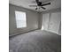 This carpeted bedroom features two closets, a ceiling fan, and natural light from a window at 6431 Furnas Rd, Indianapolis, IN 46221