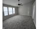 Bright bedroom with a neutral color palette, plush carpet, ceiling fan and windows for natural light at 6431 Furnas Rd, Indianapolis, IN 46221
