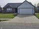 Charming single-story home with a brick accent, light blue siding and a two car garage at 6431 Furnas Rd, Indianapolis, IN 46221
