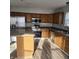 This kitchen features stainless steel appliances, wood cabinets, laminate floors, and plenty of natural light at 6431 Furnas Rd, Indianapolis, IN 46221