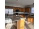This kitchen boasts stainless steel appliances, wood cabinets, a center island, and laminate floors at 6431 Furnas Rd, Indianapolis, IN 46221