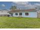 Large backyard with lush lawn, a fire pit and the home's rear elevation with bright, multi-pane windows and a sliding door at 6602 Cobden Ct, Indianapolis, IN 46254