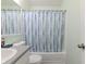 Cozy bathroom with a tub, shower curtain, light green walls, and a modern white sink at 6602 Cobden Ct, Indianapolis, IN 46254
