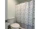 Bathroom with toilet and patterned shower curtain, maximizing space and functionality at 6602 Cobden Ct, Indianapolis, IN 46254