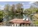 Beautiful pond with a dock and a boat, surrounded by trees, offering a serene waterfront view at 6602 Cobden Ct, Indianapolis, IN 46254