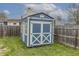 Well-maintained blue storage shed with white trim in a grassy backyard, offering ample storage space at 6602 Cobden Ct, Indianapolis, IN 46254