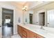 Bathroom with a double sink vanity, bright lighting, and access to a separate room with a chair at 6655 Westminster Dr, Zionsville, IN 46077