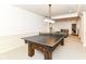 Game room with a ping pong table, light fixtures, and view to a sofa and shelving in the background at 6655 Westminster Dr, Zionsville, IN 46077