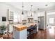 Charming kitchen with white cabinets, granite countertops, and a butcher block island at 6655 Westminster Dr, Zionsville, IN 46077