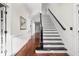 A grand staircase with black handrail and wood floors leads to the upper level of the home at 6655 Westminster Dr, Zionsville, IN 46077