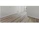 Hallway with modern wood-look flooring, neutral walls, and white trim leading to other rooms at 729 S Holmes Ave, Indianapolis, IN 46221