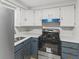 Updated kitchen with stainless steel appliances, blue cabinets, and modern countertops at 729 S Holmes Ave, Indianapolis, IN 46221