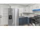 Charming kitchen with stainless steel appliances, blue lower cabinets, and white upper cabinets at 729 S Holmes Ave, Indianapolis, IN 46221