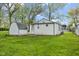 Spacious backyard with a storage shed, green grass, and trees at 733 S Holmes Ave, Indianapolis, IN 46221