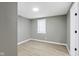 Bedroom featuring gray walls, wood-look floors, white trim and a window at 733 S Holmes Ave, Indianapolis, IN 46221