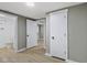Hallway with gray walls and wood-look floors leading to a bathroom at 733 S Holmes Ave, Indianapolis, IN 46221