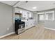 Well lit kitchen featuring white cabinets, stainless steel appliances, laminate floors, and a window above the sink at 733 S Holmes Ave, Indianapolis, IN 46221