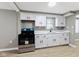 Bright kitchen features white cabinets, laminate floors, stainless steel appliances, and a window above the sink at 733 S Holmes Ave, Indianapolis, IN 46221