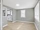 Open-concept living room with neutral walls, laminate flooring, and abundant natural light from the windows at 733 S Holmes Ave, Indianapolis, IN 46221