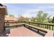 Back deck featuring built-in bench seating and green lawn, with a shed and tree line in the distance at 7901 Oaklandon Rd, Indianapolis, IN 46236