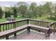 Back deck featuring built-in bench seating and green lawn, with a shed and tree line in the distance at 7901 Oaklandon Rd, Indianapolis, IN 46236