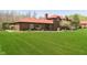 Expansive backyard features well-manicured lawn, brick home, and outdoor patio, perfect for entertaining guests and enjoying outdoor living at 7901 Oaklandon Rd, Indianapolis, IN 46236