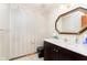 Powder room featuring a marble vanity, octagonal mirror, black toilet, and striped wallpaper at 7901 Oaklandon Rd, Indianapolis, IN 46236