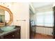 Chic bathroom featuring a glass vessel sink, elegant mirror, and convenient laundry area with modern appliances at 7901 Oaklandon Rd, Indianapolis, IN 46236