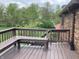 Wooden deck with built in seating, a great space for outdoor relaxation with a view of the greenery at 7901 Oaklandon Rd, Indianapolis, IN 46236