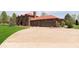 Exterior view of brick home with a red roof and two-car garage and extended circular driveway at 7901 Oaklandon Rd, Indianapolis, IN 46236