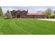 Beautiful brick two-story home with large lawn, red roof, and attached two car garage at 7901 Oaklandon Rd, Indianapolis, IN 46236