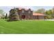 Beautiful two-story brick home with a red roof and large manicured front lawn at 7901 Oaklandon Rd, Indianapolis, IN 46236