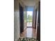 Hallway featuring open door to outside deck, hardwood floors, and neutral wallpaper at 7901 Oaklandon Rd, Indianapolis, IN 46236