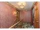 Hallway with floral wallpaper, wood railing staircase, and decorative light fixture at 7901 Oaklandon Rd, Indianapolis, IN 46236