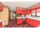 Eat-in kitchen with red cabinets, white countertops, silver dishwasher, and rooster-themed wallpaper at 7901 Oaklandon Rd, Indianapolis, IN 46236