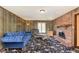 Living room with blue velvet sofa, brick fireplace, and floral carpet at 7901 Oaklandon Rd, Indianapolis, IN 46236