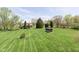 Expansive backyard with manicured lawn, mature trees, and a shed, offering a serene outdoor space at 7901 Oaklandon Rd, Indianapolis, IN 46236