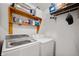 Functional laundry room featuring modern washer and dryer units and shelving at 8211 Firefly Way, Indianapolis, IN 46259