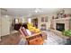 Open-concept living room with a stone fireplace, hardwood floors, and comfortable seating at 8211 Firefly Way, Indianapolis, IN 46259