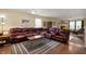 Spacious living room featuring a large leather sectional, fireplace and hardwood floors at 8211 Firefly Way, Indianapolis, IN 46259