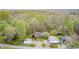Aerial view of a home and outbuildings amidst mature trees with a gravel driveway and landscaping at 8329 S Christian Dr, Nineveh, IN 46164