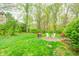 Lush backyard oasis featuring mature trees, grass and hardscape fire pit area at 8329 S Christian Dr, Nineveh, IN 46164