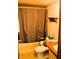 A standard bathroom with a bathtub, toilet, and vanity, featuring striped wallpaper at 9067 Old Haggard Rd, Morgantown, IN 46160