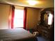 A bedroom featuring vintage wallpaper, a large window with curtains, and a wooden dresser at 9067 Old Haggard Rd, Morgantown, IN 46160